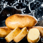 54926731 – potato with water splash on black background